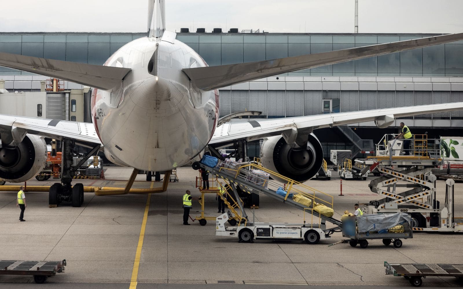 Ground crew loading baggage onto an aircraft at the gate